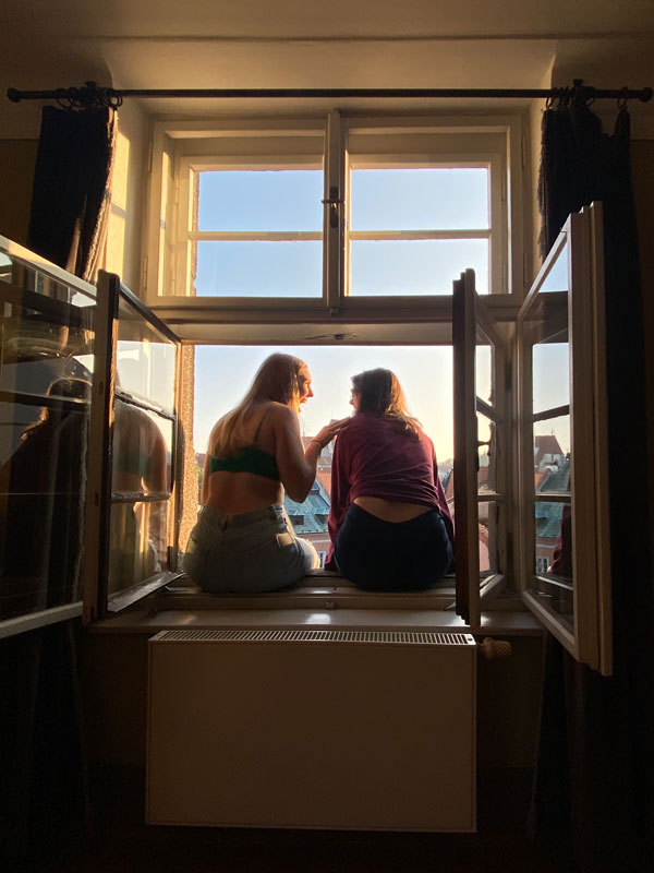 two students sitting in a window