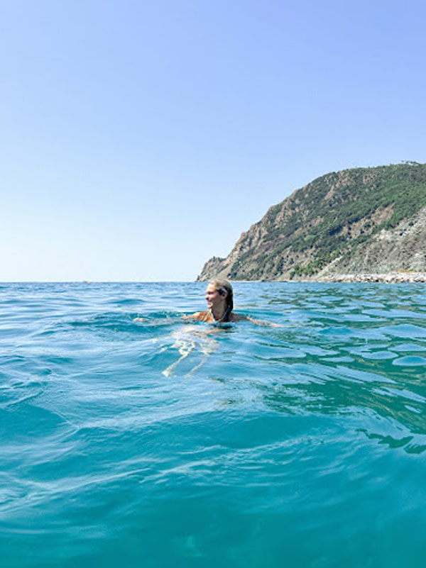 person swimming in blue ocean water