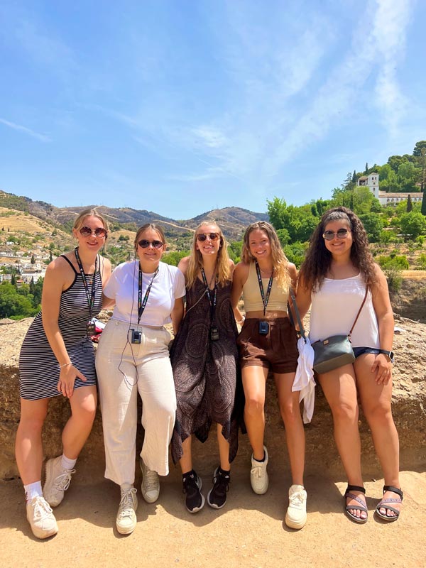 5 people pose for picture outside of work conference