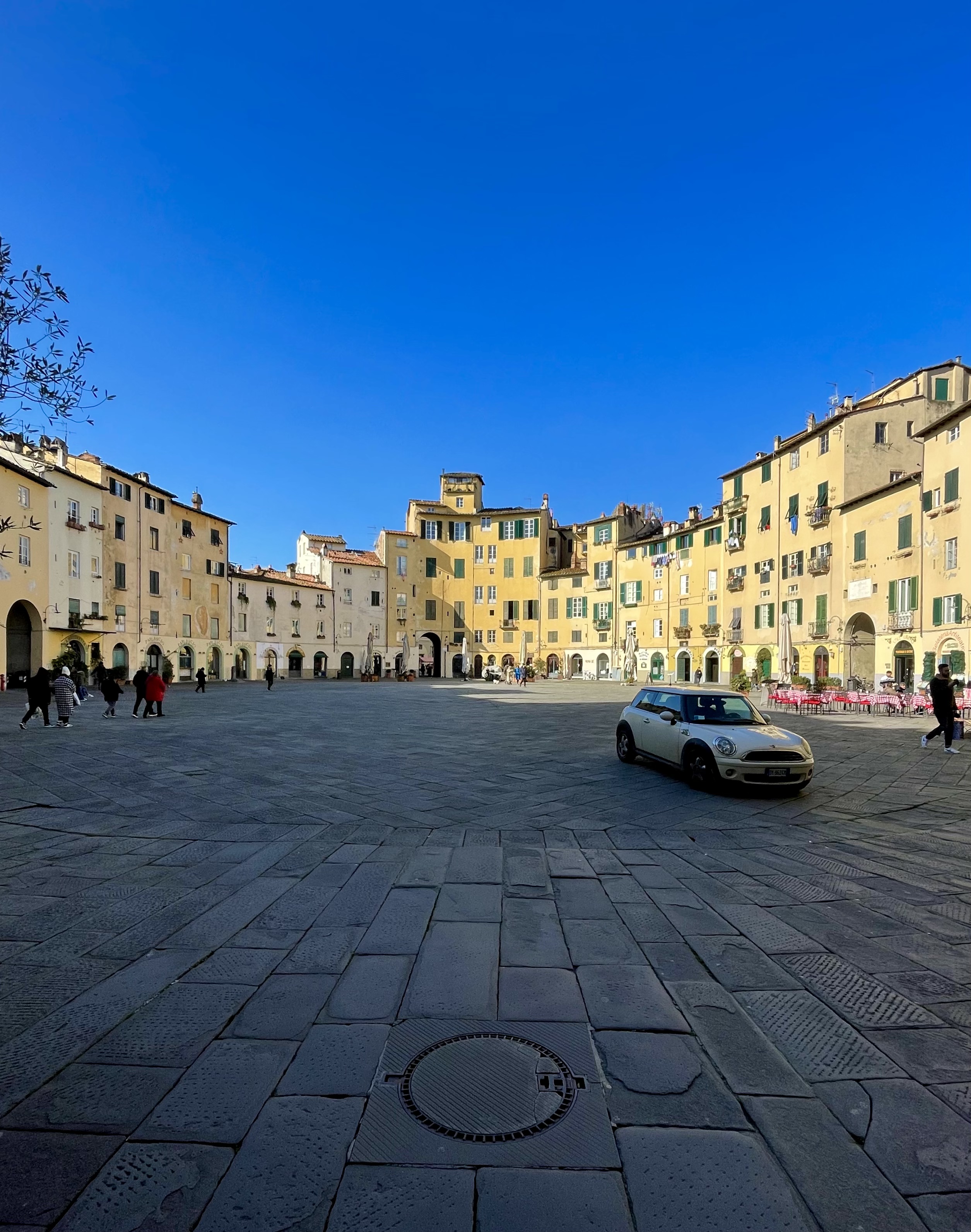 A yellow building and mini cooper car in Lucca, Italy