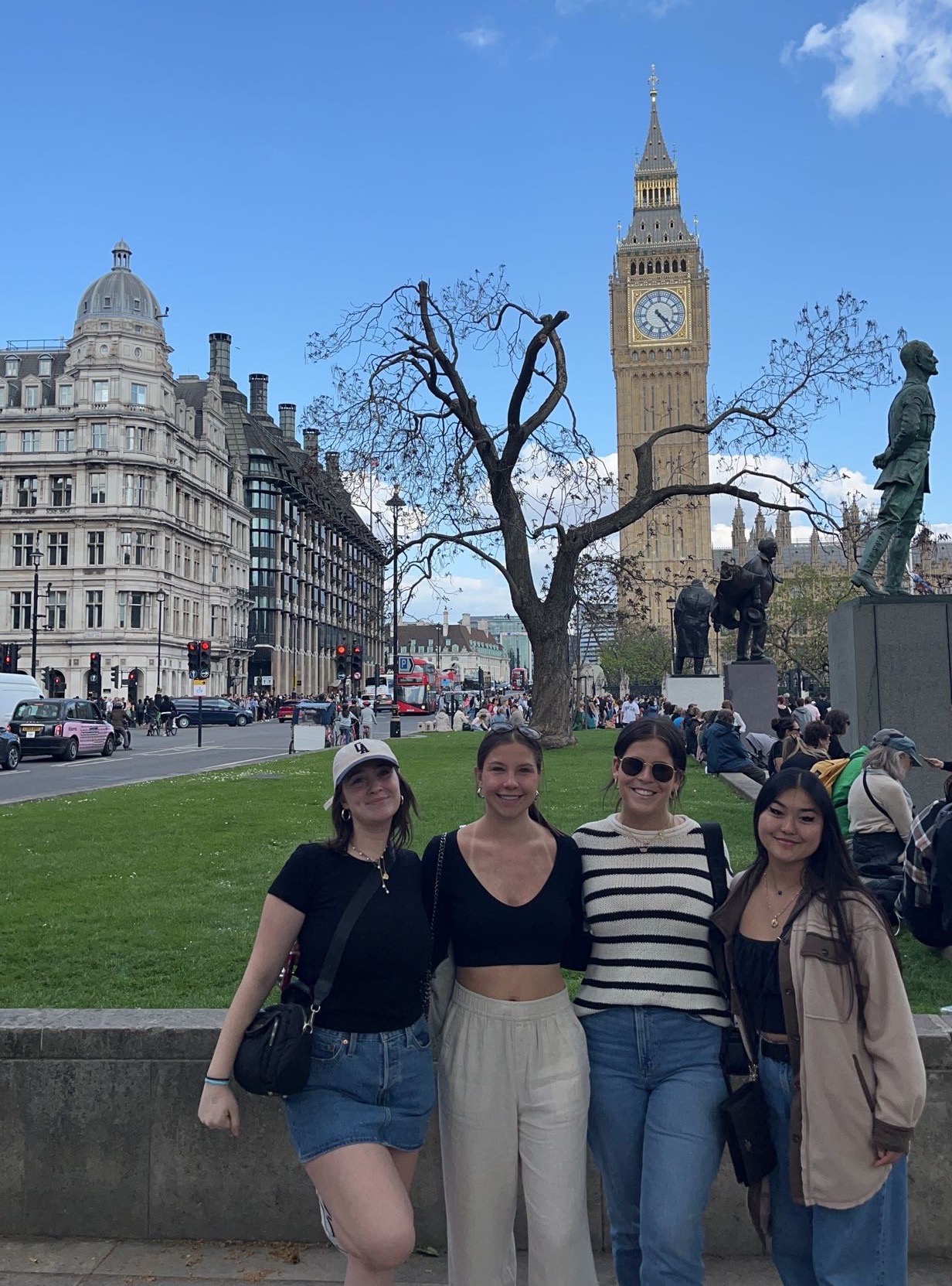 Four students standing and smiling in the foreground with the Big Ben in the background.