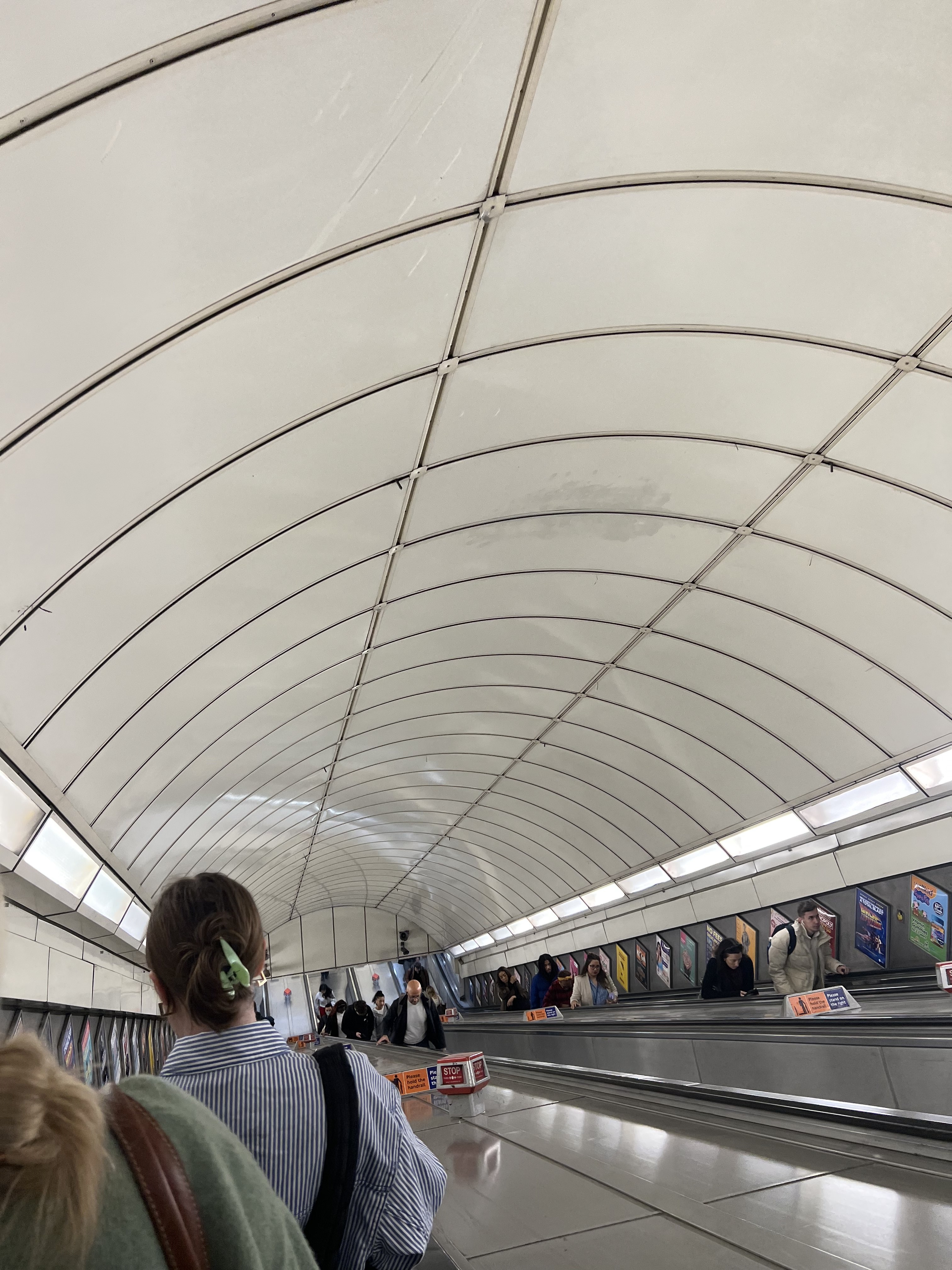 Going down on an escalator indoors.