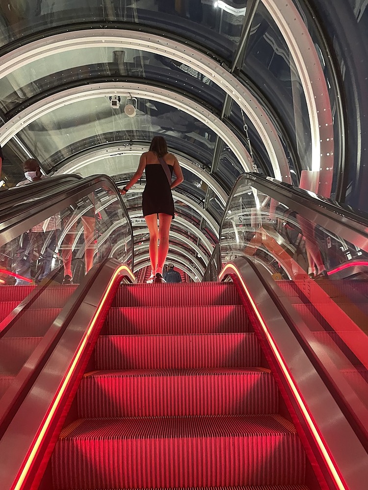 Student riding up the (red) escalator