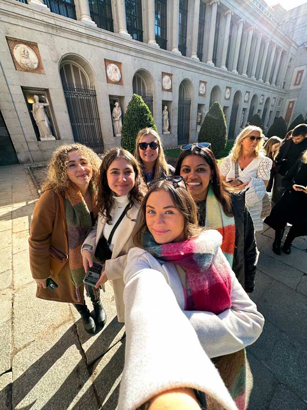 Students take front-facing camera picture in front of a Museum