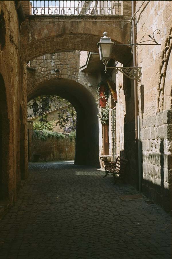 Tan arches and cobblestone walkway in Italy