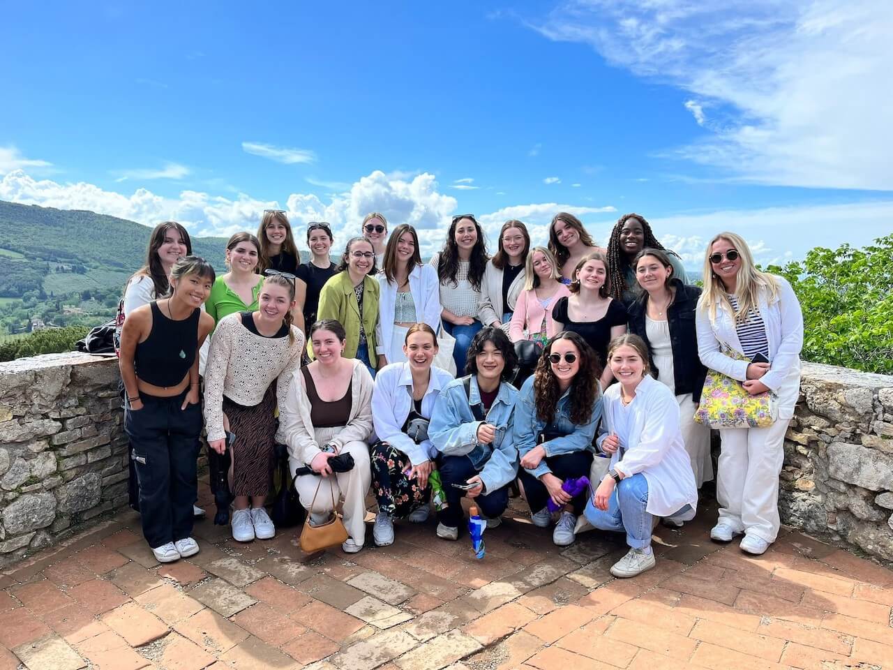 A big group of students standing and smiling together in San Gimignano, Italy