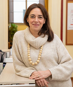 A person wearing a sweater and a large beaded necklace